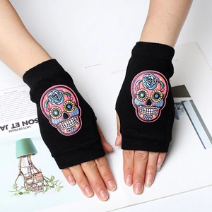 Close-up of black fingerless knit gloves with colorful sugar skull embroidery detail