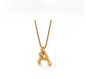 Detail view of gold stainless steel necklace with bamboo texture A-letter pendant and zircon