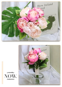 Detail of pink and cream silk peony bouquet with green leaves and home decor styling