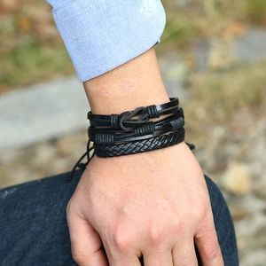 Men's vintage black multilayer leather bracelet set worn by a model in natural light