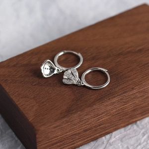 Close-up of S925 sterling silver shell earrings with sparkling zircons on wood