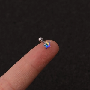 Star-shaped crystal ear stud on a fingertip showing minimalist stainless steel design