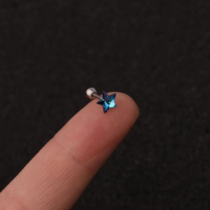 Exquisite stainless steel ear stud featuring a blue star-shaped crystal held on a fingertip