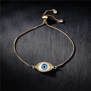 Adjustable gold evil eye bracelet with blue resin eye charm and sliding bead clasp