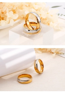 Close-up of two-tone gold stainless steel couple rings with elegant diamond inlay and sleek finish