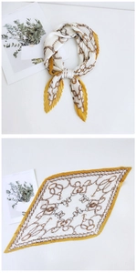 Detail of pleated silk scarf with gold chain print in vibrant yellow and white tones