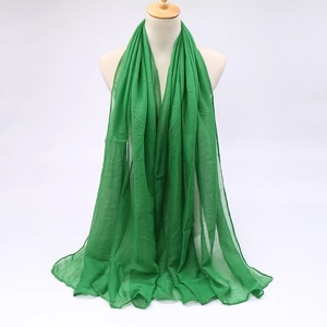 Macro detail of vibrant lime green lightweight scarf showing sheer fabric and drape