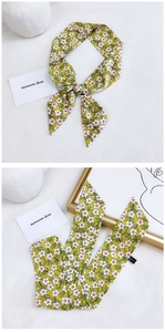 Detail of a 100% cotton yellow floral skinny scarf showing texture and small flower print