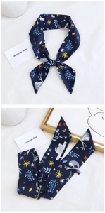 Detail of navy blue cotton skinny scarf with koala and floral print on white background