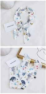 Detail showing 100% cotton long scarf with cute koala and sloth patterns and bow tie styling
