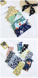Close-up of various printed cotton linen scarves with floral and animal patterns
