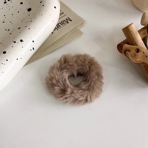 Dettaglio dell'elastico in peluche marrone caffè con foro a cuore su vassoio