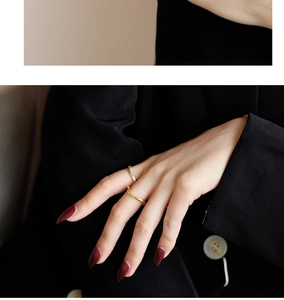 Dettaglio di anelli irregolari minimalisti color oro e argento sulle dita