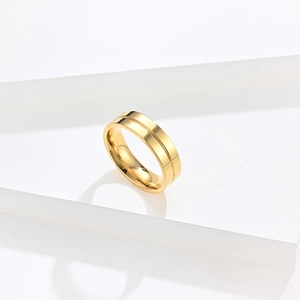 Detailed macro view of gold plated titanium steel ring with central groove on white stand