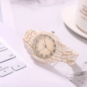 Bamboo style wood watch on a laptop keyboard with a marble desk background