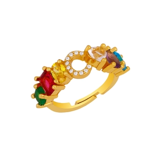 Macro detail of gold adjustable ring with multi-color gemstones and crystal letter C