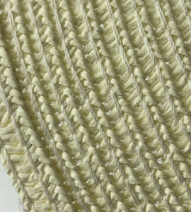 Macro shot of tight twill weave texture on a cream-colored straw sun hat surface