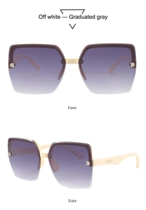 Detail of off-white semi-rimless sunglasses with graduated gray lenses and gold accents