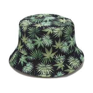 Detail of tropical leaf print on canvas sun hat with green foliage patterns