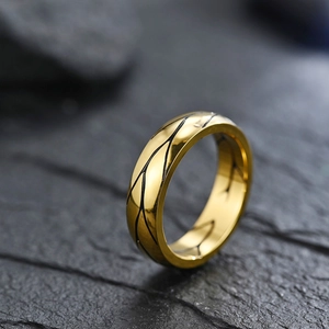 Macro shot of gold-plated titanium ring with black leaf vein pattern on stone surface