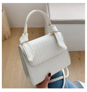 Detailed view of white crocodile pattern on faux leather mini square handbag