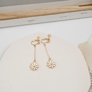 Detail of daisy drop earrings for unpierced ears on a decorative ceramic plate