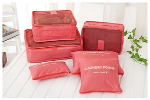 Close-up of 6-piece coral pink travel organizer set with mesh bags and laundry pouches