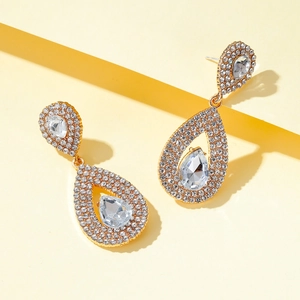 Macro view of gold-plated teardrop earrings with pear-cut cubic zirconia and micro-pavé setting