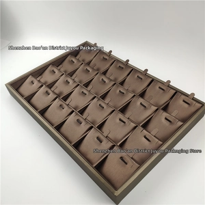 Detailed view of a 24-slot brown satin jewelry display tray for necklaces and pendants