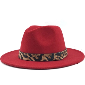 Detail of red fedora hat featuring leopard print band and gold metal rivet accessory