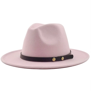 Detail of pink wool fedora hat featuring a dark leather band and gold rivet accents