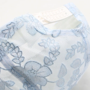 Close-up of light blue floral lace embroidery on white mesh sun hat for women