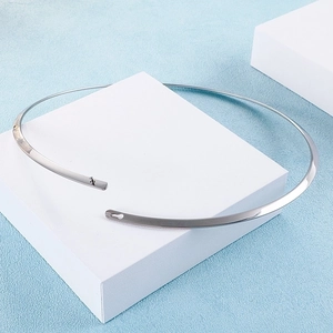 Polished silver titanium steel open choker necklace displayed on a white geometric stand