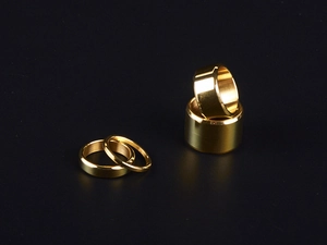 Macro shot of a four-piece set of polished gold titanium steel rings on black background