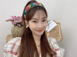 Detailed embroidery of colorful floral patterns on a wide black bohemian style headband