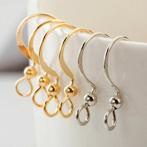 Macro di ganci per orecchini in argento 925 oro e argento appesi a una tazza di porcellana