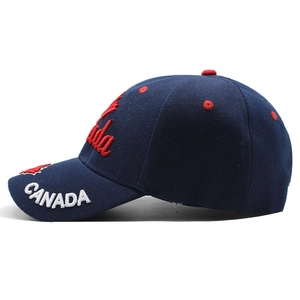 Detail of navy blue baseball cap showing white CANADA embroidery and red maple leaf stitch