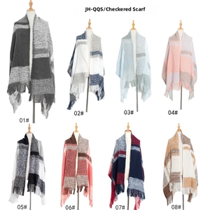 Macro shot showing eight plaid patterns and soft bouclé texture of the winter tassel scarf