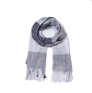 Close-up of black and white checkered knit scarf with tassels on white background