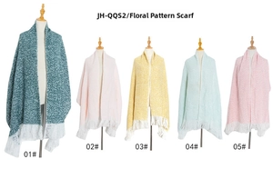 Detail of bouclé yarn scarves in five colors with white tassels on mannequins
