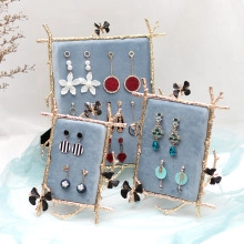 Three-piece set of light blue velvet earring display stands with gold butterfly metal frames