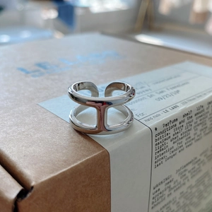 Macro detail of the double-layer silver anchor link ring on minimalist packaging