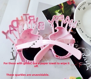 Pink cupcake-shaped birthday sunglasses with glittery Happy Birthday text detail
