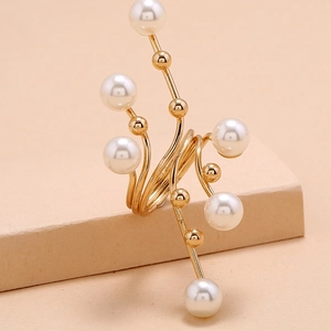 Detail of a gold geometric ring with radioactive branch design and white pearls