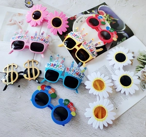 Flat lay of colorful daisy and birthday cake party sunglasses with glitter finish