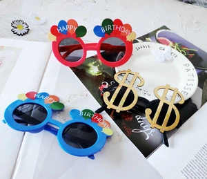 Flat lay of plastic novelty birthday party glasses with sequins and dollar sign details