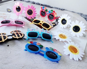 Collection of novelty daisy and happy birthday party sunglasses for fun photo props