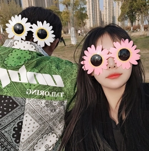 Outdoor model shot of white and pink daisy flower shaped funny novelty sunglasses