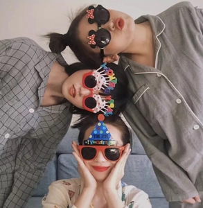 Close-up of guests wearing fun birthday party sunglasses with glitter and festive patterns