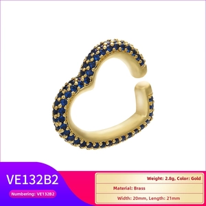 Macro detail of heart-shaped brass ear cuff with micro-pave blue cubic zirconia crystals